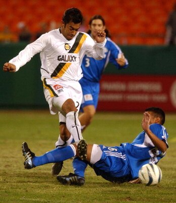 KANSAS CITY, MO - NOVEMBER 5:  Forward Carlos Ruiz #20 of the Los Angeles Galaxy runs over defender Jose Burciaga Jr. #6 of the Kansas City Wizards during the Major League Soccer Western Conference final on November 5, 2004 at Arrowhead Stadium in Kansas 