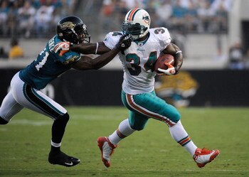 JACKSONVILLE, FL - AUGUST 16:  Running back Ricky Williams #34 of the Miami Dolphins is tackled by Drayton Florence #21 of the Jacksonville Jaguars at Jacksonville Municipal Stadium on August 16, 2008 in Jacksonville, Florida.  (Photo by Sam Greenwood/Get