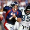 25 Oct 1998: Quarterback John Elway #7 of the Denver Broncos runs as he avoids being sacked by Bryce Paup #95 of the Jacksonville Jaguars at Mile High Stadium in Denver, Colorado. The Broncos defeated the Jaguars 37- 24.