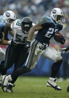NASHVILLE, TN - NOVEMBER 16:  Eddie George #27 of the Tennessee Titans runs past Hugh Douglas #58 of the Jacksonville Jaguars on November 16, 2003 at The Coliseum in Nashville, Tennessee. The Titans won 10-3.  (Photo by Elsa/Getty Images)
