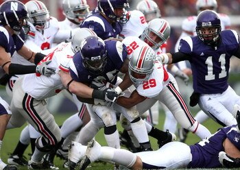 EVANSTON, IL - NOVEMBER 08:  Stephan Simmons #25 of the Northwestern Wildcats is tackled by Shaun Lane #29 and Austin Spitler #38 of the Ohio State Buckeyes at Ryan Stadium on November 8, 2008 in Evanston, Illinois  (Photo by Jonathan Ferrey/Getty Images)