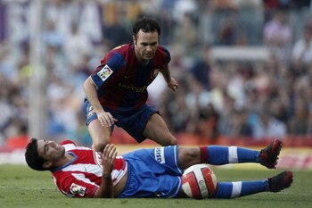 BARCELONA, SPAIN - OCTOBER 07: Andres Iniesta (R) of Barcelona challenges a fallen Jose Antonio Reyes of Atletico de Madrid during the Primera Liga match between Barcelona and Atletico de Madrid at the Camp Nou stadium on October 7, 2007 in Barcelona, Spa