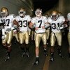 LOS ANGELES, CA - NOVEMBER 29:  Quarterback Jimmy Clausen #7 of the Notre Dame Fighting Irish walks out with teammates Robert Hughes #33 and Sergio Brown #31 before the game against the USC Trojans at Los Angeles Memorial Coliseum on November 29, 2008 in 