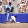 1990:  Frank White #20 of the Kansas City Royals tries to turn a double play as he throws to first base after forcing out the sliding runner at second base during a game in 1990.  (Photo by Otto Greule Jr/Getty Images)
