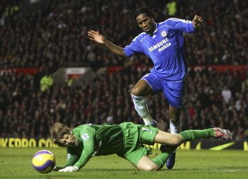 MANCHESTER, UNITED KINGDOM - NOVEMBER 26: Edwin van der Sar of Manchester United dives at the feet of Didier Drogba of Chelsea during the Barclays Premiership match between Manchester United and Chelsea at Old Trafford on November 26, 2006 in Manchester, 