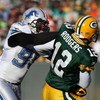 GREEN BAY, WI - DECEMBER 28: Aaron Rodgers #12 of the Green Bay Packers is hit by Dewayne White #99 of the Detroit Lions on December 28, 2008 at Lambeau Field in Green Bay, Wisconsin. The Packers defeated the Lions 31-21. (Photo by Jonathan Daniel/Getty I