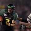 SAN DIEGO, CA - DECEMBER 30:   Quarterback Jeremiah Masoli #2 of the University of Oregon Ducks runs into the endzone for a touchdown against the tackle of Free Safety Quinton Moore #26 of the Oklahoma State University Cowboys during the Pacific Life Holi
