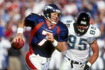 25 Oct 1998: Quarterback John Elway #7 of the Denver Broncos runs as he avoids being sacked by Bryce Paup #95 of the Jacksonville Jaguars at Mile High Stadium in Denver, Colorado. The Broncos defeated the Jaguars 37- 24.