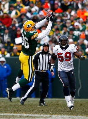 GREEN BAY, WI - DECEMBER 07:  Donald Lee #86 of the Green Bay Packers makes a reception in front of DeMeco Ryans #59 of the Houston Texans during the first half at Lambeau Field on December 7, 2008 in Green Bay, Wisconsin. The Texans defeated the Packers 