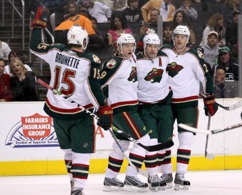 LOS ANGELES - MARCH 7:  (L to R) Andrew Brunette #15, Mikko Koivu #9, Owen Nolan #11, and Kurtis Foster #26 of the Minnesota Wild celebrate Nolan's first period goal against the Los Angeles Kings on March 7, 2009 at Staples Center in Los Angeles, Californ
