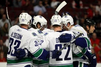 CHICAGO - MAY 05:  (L-R) Henrik Sedin #33, Steve Bernier #18, Daniel Sedin #22 and Alexander Edler #23 of the Vancouver Canucks celebrate after Bernier scored a goal in the third period against the Chicago Blackhawks during Game Three of the Western Confe