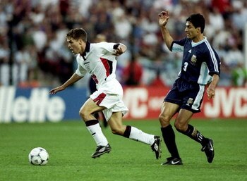 30 Jun 1998:  Michael Owen of England shrugs off Jose Chamot of Argentina on his way to goal during the World Cup second round match at the Stade Geoffroy Guichard in St Etienne, France. England lost 4-3 on penalties after a 2-2 draw. \ Mandatory Credit:R