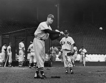 BOSTON, MA - CIRCA 1945:  (UNDATED FILE PHOTO)  Baseball legend Ted Williams (1919 - 2002) of the Boston Red Sox swings a bat at a ball during a pre-game practice as Walter 'Smokey' Baker, the 13-year-old son of Red Sox pitching coach Del Baker (1892 - 19