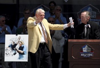 CANTON, OH - AUGUST 05:  Broadcaster and former coach Oakland Raider John Madden (L) gestures in front of a portrait of him after being introduced by Oakland Raider owner Al Davis during his induction during the Class of 2006 Pro Football Hall of Fame Ens
