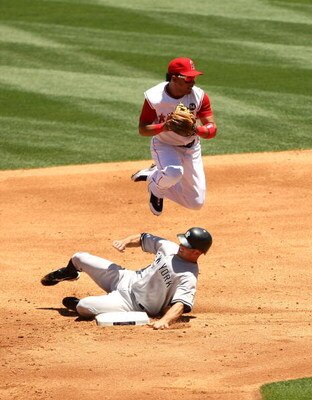 ANAHEIM, CA - JULY 12:   Shortstop Maicer Izturis #13 of the Los Angeles Angels of Anaheim jumps over Brett Gardiner #11 of the New York Yankees but has to hold the ball on the double play attempt in the third inning on July 12, 2009 at Angel Stadium in A