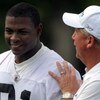CHARLOTTE,NC- MAY 1: First round draft pick Everette Brown #91 of the Carolina Panthers smiles as Head Coach John Fox (R) pats him on the back as they walk off the field the minicamp practice at the team's practice facility on May 1, 2009 in Charlotte, No