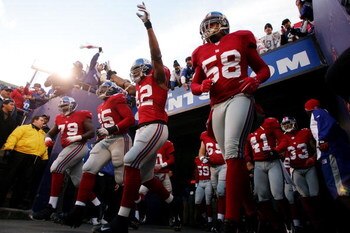 EAST RUTHERFORD, NJ - DECEMBER 03: Guy Whimper #79, Adrian Awasom #95, Visanthe Shiancoe #82 and Antonio Pierce #58 of the New York Giants take the field before a game against the Dallas Cowboys at Giants Stadium on December 3, 2006 in East Rutherford, Ne