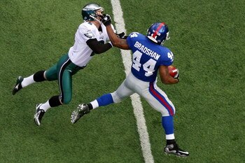 EAST RUTHERFORD, NJ - JANUARY 11:  Ahmad Bradshaw #44 of the New York Giants stiff arms kicker David Akers #2 of the Philadelphia Eagles on a return during the NFC Divisional Playoff Game on January 11, 2009 at Giants Stadium in East Rutherford, New Jerse