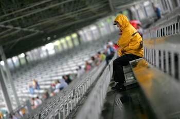 INDIANAPOLIS - JULY 25:  A fan sits in the stands during a rain delay before qualifying for the NASCAR Sprint Cup Series Allstate 400 at the Brickyard at Indianapolis Motor Speedway on July 25, 2009 in Indianapolis, Indiana.  (Photo by Ezra Shaw/Getty Ima