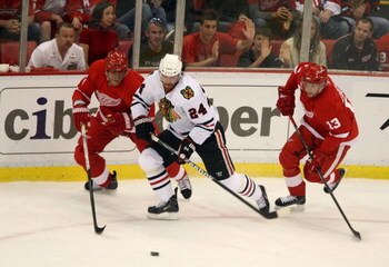DETROIT - MAY 17:  Martin Havlat #24 of the Chicago Blackhawks attempts to control the puck against Marian Hossa (L) #81 and Pavel Datsyuk #13 of the Detroit Red Wings during the first period of Game One of the Western Conference Championship Round of the