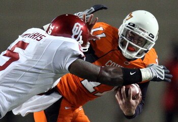 STILLWATER, OK - NOVEMBER 29:  Quarterback Zac Robinson #11 of the Oklahoma State Cowboys runs the ball against Nic Harris #5 of the Oklahoma Sooners at Boone Pickens Stadium on November 29, 2008 in Stillwater, Oklahoma.  (Photo by Ronald Martinez/Getty I