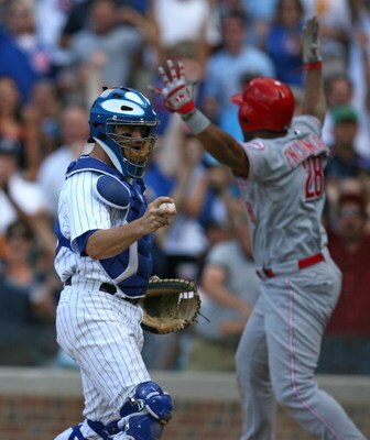 CHICAGO - JULY 26: Koyie Hill #55 of the Chicago Cubs holds the ball after a play at the plate as Edwin Encarnacion #28 of the Cincinnati Reds protests the call on July 26, 2009 at Wrigley Field in Chicago, Illinois. The Cubs defeated the Reds 5-2.  (Phot