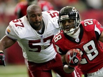 ATLANTA - SEPTEMBER 26:  Warrick Dunn #28 of the Atlanta Falcons carries the ball up the field as a helmetless Ronald McKinnon #57 of the Arizona Cardinals gives chase during the game on September 26, 2004 at the Georgia Dome in Atlanta, Georgia.  (Photo 