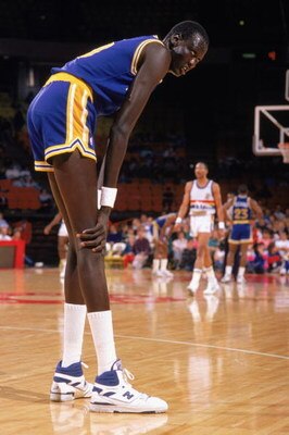 1988:  Manute Bol #10 of the Golden State Warriors rests on the court during an NBA game in the 1988-89 season. NOTE TO USER: User expressly acknowledges and agrees that, by downloading and/or using this Photograph, User is consenting to the terms and con