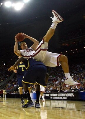 KANSAS CITY, MO - MARCH 21:  Blake Griffin #23 of the Oklahoma Sooners falls on the back of Manny Harris #3 of the Michigan Wolverines during the second round of the NCAA Division I Men's Basketball Tournament at the Sprint Center on March 21, 2009 in Kan