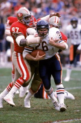 SAN FRANCISCO - JANUARY 6:  Defensive tackle Gary Johnson #97 and linebacker Riki Ellison #50 of the San Francisco 49ers stop Chicago Bears running back Matt Suhey #26 during the 1984 NFC Championship Game at Candlestick Park on January 6, 1985 in San Fra