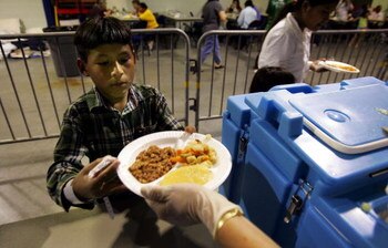 ESTERO, FL - OCTOBER 23:  A boy gets food from the Red Cross in Germain Arena, a sports stadium being used as a hurricane shelter, October 23, 2005 in Estero, Florida.  Hurricane Wilma continued its march toward the Florida Gulf coast October 23, and thou