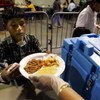ESTERO, FL - OCTOBER 23:  A boy gets food from the Red Cross in Germain Arena, a sports stadium being used as a hurricane shelter, October 23, 2005 in Estero, Florida.  Hurricane Wilma continued its march toward the Florida Gulf coast October 23, and thou