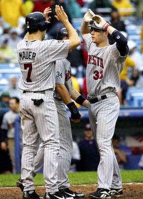 NEW YORK - SEPTEMBER 2:  Justin Morneau #33 of the Minnesota Twins is met at home by teammates Michael Cuddyer #5 and Joe Mauer #5 after hitting a three run home run in the eigth inning against the New York Yankees at Yankee Stadium September 2, 2006 in t