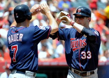 ANAHEIM, CA - JULY 26:  Justin Morneau #33 of the Minnesota Twins celebrates his two-run home run with teammate Joe Mauer #7 during the first inning against the Los Angeles Angels of Anaheim at Angels Stadium on July 26, 2009 in Anaheim, California. (Phot