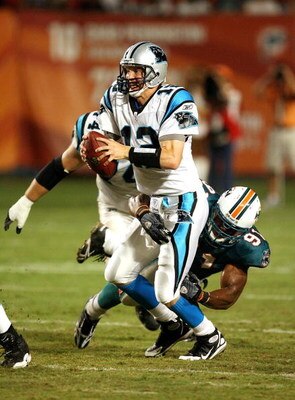 MIAMI - AUGUST 22:  Quarterback Josh McCown #12 of the Carolina Panthers tries to get rid of the ball as he is brought down by linebacker Cameron Wake #91 of the Miami Dolphins during a pre-season game at Land Shark Stadium on August 22, 2009 in Miami, Fl
