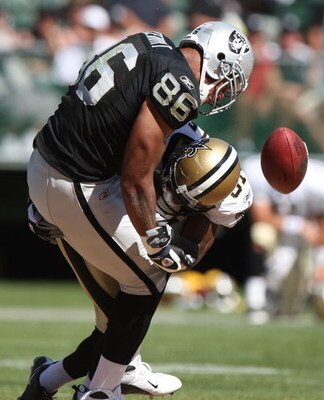 OAKLAND, CA - AUGUST 29: Tony Stewart #86 of the Oakland Raiders is hit after a catch by Pierson Prioleau #31 of the New Orleans Saints during an NFL preseason game at Oakland-Alameda County Coliseum on August 29, 2009 in Oakland, California. (Photo by Je