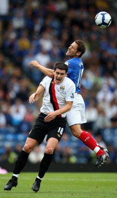 PORTSMOUTH, ENGLAND - AUGUST 30: Michael Brown of Portsmouth goes up for the ball against Gareth Barry of Manchester City during the Barclays Premier League match between Portsmouth and Manchester City at Fratton Park on August 30, 2009 in Portsmouth, Eng