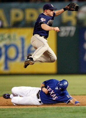 ARLINGTON, TX - JUNE 28:  Second baseman David Eckstein #3 of the San Diego Padres turns the double play over the slide by Michael Youg #10 of the Texas Rangers to end the game on June 28, 2009 at Rangers Ballpark in Arlington, Texas.  (Photo by Ronald Ma
