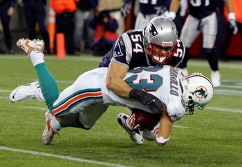 FOXBORO, MA - DECEMBER 23:  Tedy Bruschi #54 of the New England Patriots tackles Greg Camarillo #83 of the Miami Dolphins during their game at Gillette Stadium on December 23, 2007 in Foxboro, Massachusetts.  (Photo by Jim McIsaac/Getty Images)