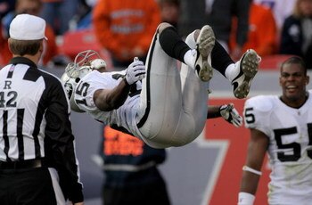 DENVER - NOVEMBER 23:  Johnnie Lee Higgins #15 of the Oakland Raiders celebrates with a back flip in front of referee Jeff Triplette after his 89 yard punt return for a second quarter touchdown against the Denver Broncos during week 12 NFL action at Inves
