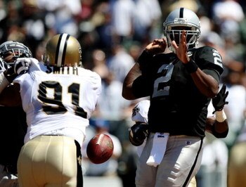 OAKLAND, CA - AUGUST 29:  Quarterback JaMarcus Russell #2 of the Oakland Raiders has the ball knocked loose by a New Orleans Saints defender during the preseason game at Oakland-Alameda County Coliseum on August 29, 2009 in Oakland, California. (Photo by 