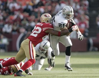 SAN FRANCISCO - AUGUST 22:  Oakland Raiders running back Justin Fargas #25 tries to break a tackle by San Francisco 49ers cornerback Nate Clements #22 during the 2nd quarter as the San Francisco 49ers host the Oakland Raiders at Candlestick Park August 22