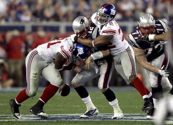 GLENDALE, AZ - FEBRUARY 03:  Tom Brady #12 of of the New England Patriots fumbles the ball in the second quarter as he is hit by Justin Tuck #91 and Osi Umenyiora #72 of the New York Giants during Super Bowl XLII on February 3, 2008 at the University of P