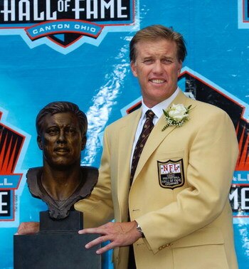 CANTON, OH - AUGUST 8:  Pro Football Hall of Fame enshrinee John Elway poses with his bust during the 2004 NFL Hall of Fame enshrinement ceremony August 8, 2004 in Canton, Ohio.  (Photo by David Maxwell/Getty Images)