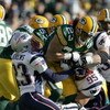 GREEN BAY, WI - NOVEMBER 19:  Noah Herron #23 of the Green Bay Packers grips the ball as he is tackled by  Willie Andrews #23 and Tully Banta- Cain #95 of the New England Patriots on November 19, 2006 at Lambeau Field in Green Bay, Wisconsin. The Patriots
