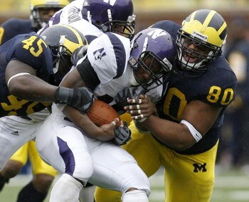 ANN ARBOR, MI - OCTOBER 28:  Terell Sutton #19 of the Northwestern Wildcats gets taken down by Alan Branch #80 and David Harris #45 of the Michigan Wolverines on October 28, 2006 at Michigan Stadium in Ann Arbor, Michigan. Michigan defeated Northwestern 1
