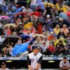 DENVER - JULY 25:  Garrett Atkins #27 of the Colorado Rockies takes an at bat as fans protect themselves from the rain with umbrellas against the San Francisco Giants at Coors Field on July 25, 2009 in Denver, Colorado. The Rockies defeated the Giants 8-2