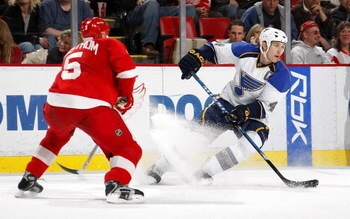 DETROIT - MARCH 28:  Eric Brewer #4 of the St.Louis Blues carries the puck as he is defended by Nicklas Lidstrom #5 of the Detroit Red Wings during their NHL game at Joe Louis Arena March 28, 2008 in Detroit, Michigan.(Photo By Dave Sandford/Getty Images)
