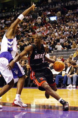 TORONTO - DECEMBER 12:  Dwyane Wade #3 of the Miami Heat drives past Chris Bosh #4 of the Toronto Raptors on December 12, 2004 at the Air Canada Centre in Toronto, Ontario, Canada.  NOTE TO USER: User expressly acknowledges and agrees that, by downloading