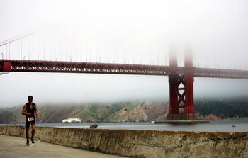 SAN FRANCISCO - JUNE 04:  Jeffrey Neal runs along the Marina, with the Golden Gate partially obscured by fog in the background, during the Escape from Alcatraz Triathlon on June 4, 2006 in San Francisco, California.  (Photo by Donald Miralle/Getty Images)